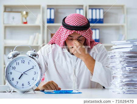 Arab businessman working in the office doing paperwork with a pi Arab businessman working in the office doing paperwork with a pi 71026470