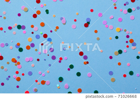 Multicolored round sequins on a pastel blue background with confetti. Multicolored round sequins on a pastel blue background with confetti. 71026668