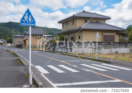 在穿過農村居民區的道路上繪製的人行橫道和兒童站立標誌 71027089