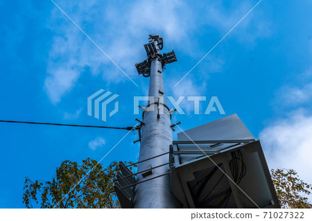 Cellular towers against the blue sky with white clouds view from below are visible derriere Cellular towers against the blue sky with white clouds view from below are visible derriere 71027322