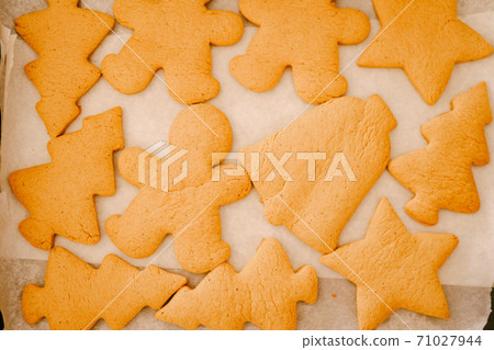 Close-up of a set of gingerbread cookies on baking paper. Close-up of a set of gingerbread cookies on baking paper. 71027944