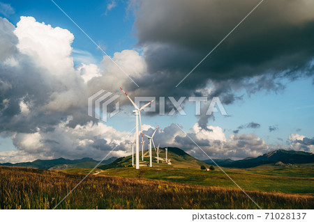 Wind turbines in the field against the backdrop of an epic sky. 71028137