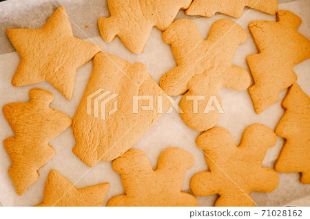 Close-up of a set of gingerbread cookies on baking paper. Close-up of a set of gingerbread cookies on baking paper. 71028162