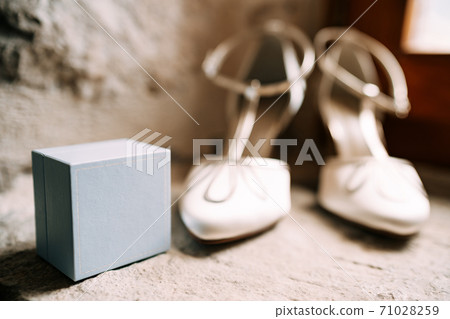 Bride's shoe ring box in white in a room with shallow depth of field. Bride's shoe ring box in white in a room with shallow depth of field. 71028259