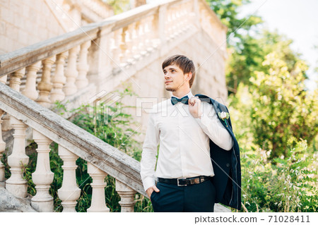 groom on the stairs of the Nativity of the Blessed Virgin Mary church in Prcanj groom on the stairs of the Nativity of the Blessed Virgin Mary church in Prcanj 71028411