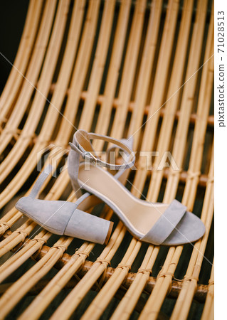 Bridal sandals close-up on a chair made of wooden rods. Bridal sandals close-up on a chair made of wooden rods. 71028513