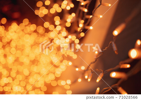 Festive background with LED lights garland. Christmas and New Year background. Blurred bokeh from the lights of a garland. 71028566