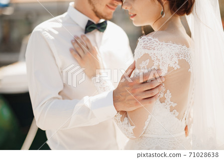 close-up bride and groom are hugging tenderly close-up bride and groom are hugging tenderly 71028638