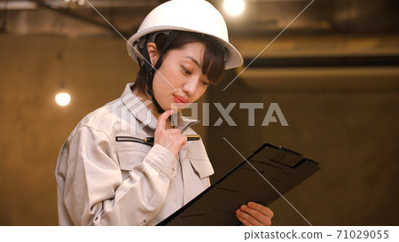 檢查進展的女商人在建造場所 71029055