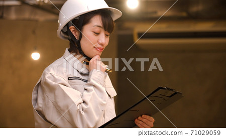 檢查進展的女商人在建造場所 71029059