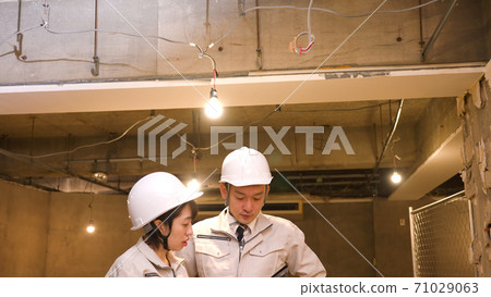 檢查進展的女商人在建造場所 71029063