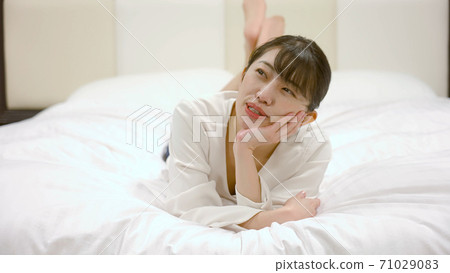 一個女人在旅館的床上嬉戲 71029083