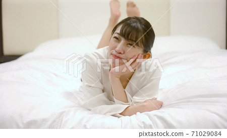一個女人在旅館的床上嬉戲 71029084