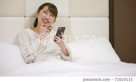 Woman frolicking on the hotel bed Woman frolicking on the hotel bed 71029115