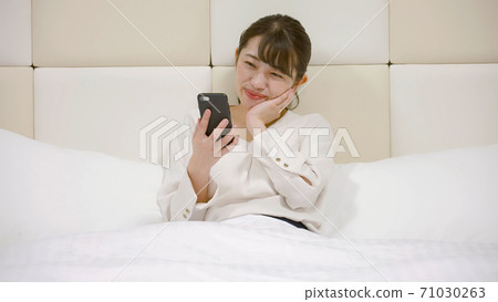 一個女人在旅館的床上嬉戲 71030263