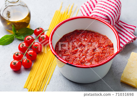 Traditional tomato sauce in saucepan with spaghetti pasta. Grey background. Close up. 71031698