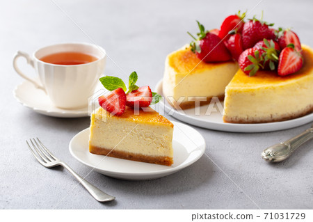 Cheesecake dessert with fresh strawberries and cup of tea. Grey background. 71031729