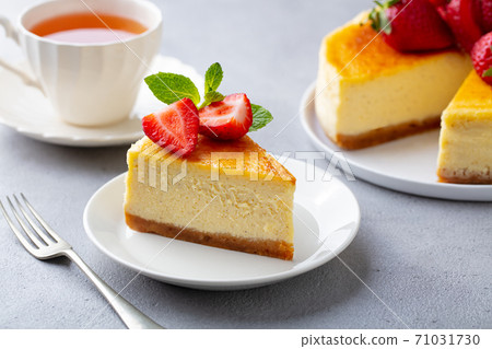 Cheesecake dessert with fresh strawberries and cup of tea. Grey background. Close up. Cheesecake dessert with fresh strawberries and cup of tea. Grey background. Close up. 71031730