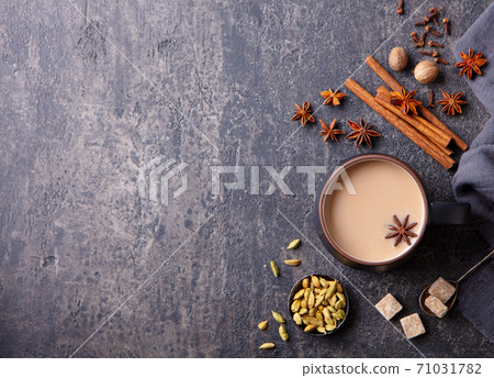 Indian masala tea with milk and spices in mug. Grey background. Copy space. Top view. 71031782
