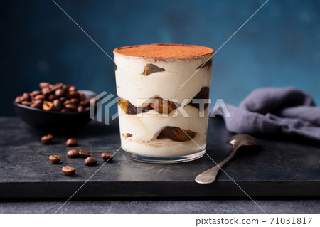 Tiramisu dessert in glass on marble board. Blue background. Close up. 71031817