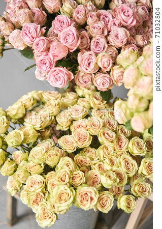 Big luxury bright bouquet peony rose on wooden table. Garden spray roses of lilac, pink and green color . bouquet in metal vase 71032804