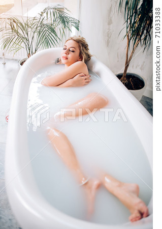 Blonde woman relaxing in bath 71033388