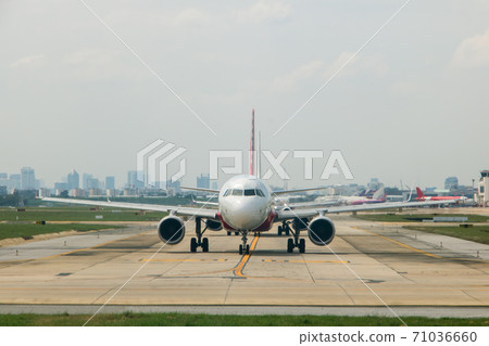 A planes in line waits for departure from the airport at Don Mueang International Airport. A planes in line waits for departure from the airport at Don Mueang International Airport. 71036660