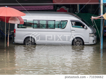 Van are moving in a flooded street. Floods in the market in Samut Prakan, Thailand Van are moving in a flooded street. Floods in the market in Samut Prakan, Thailand 71036662