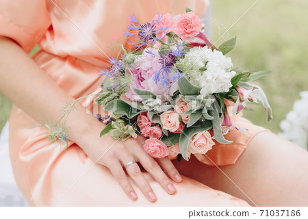 beautiful girl in a bathrobe with a bouquet of flowers on nature in summer on a background of green leaves beautiful girl in a bathrobe with a bouquet of flowers on nature in summer on a background of green leaves 71037186