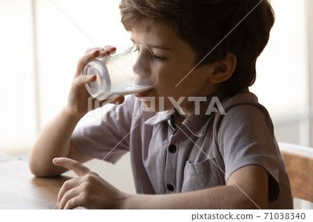 Little boy child drink healthy organic milk from glass 71038340