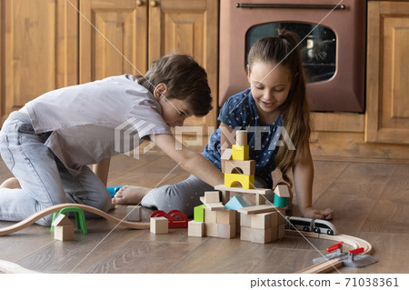 Happy small kids play with wooden railroad at home 71038361