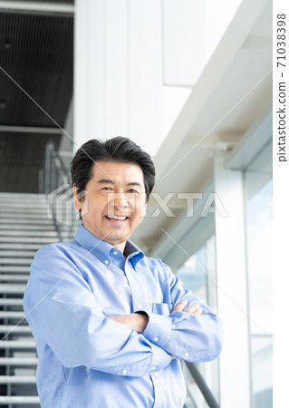 Portrait of a senior man standing in the office lobby Portrait of a senior man standing in the office lobby 71038398
