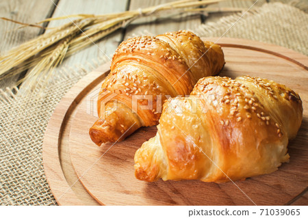 Freshly baked croissants on wooden cutting board, top view 71039065