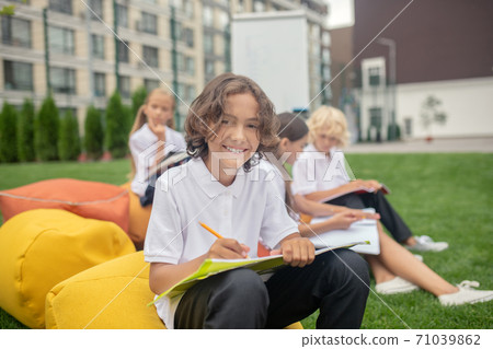 Dark-haired schoolboy in white shirt looking happy 71039862