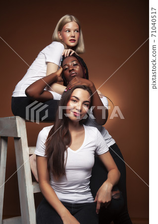 young pretty asian, caucasian, afro woman posing cheerful together on brown background, lifestyle diverse nationality people concept young pretty asian, caucasian, afro woman posing cheerful together on brown background, lifestyle diverse nationality people concept 71040517