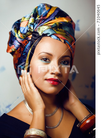 beauty bright african woman with creative make up, shawl on head like cubian closeup smiling 71040645