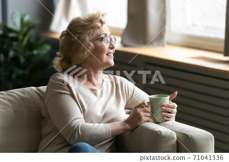 Happy retired woman enjoying morning ritual, drinking coffee. 71041336
