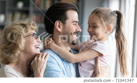 Affectionate three generations family enjoying sweet moment at home. 71041347