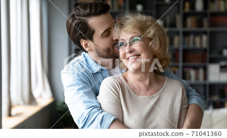 Affectionate grown son feeling appreciation to mature elderly mother. Affectionate grown son feeling appreciation to mature elderly mother. 71041360