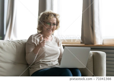Emotional happy 60s mature beautiful woman showing thumbs up gesture. 71041366