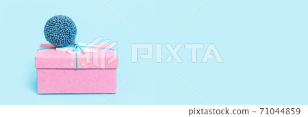 Red Christmas gift box with blue bauble on blue Red Christmas gift box with blue bauble on blue 71044859