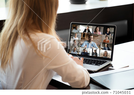 Close up rear view businesswoman talking with diverse colleagues online 71045031