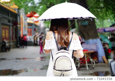 一名身穿白衣的女人走在Hajihama的街道上 71045356