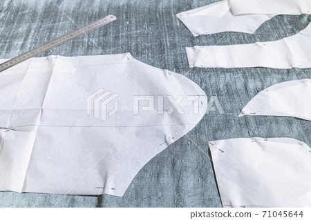 fixed paper sewing pattern layouts on gray fabric 71045644