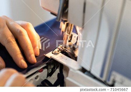 seamstress processes edge of fabric on overlocker 71045667