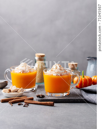 Pumpkin spice latte with whipped cream in glass cups. Grey background. Copy space. 71045987