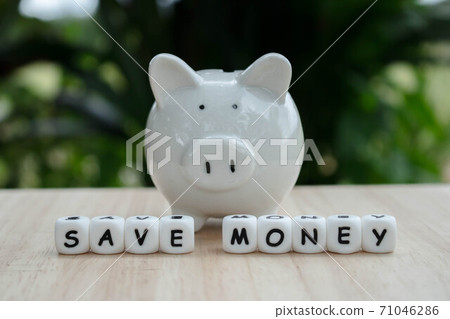 Dice the word "SAVE MONEY" and piggy bank money save coins.   Block of alphabet studded on wooden background. money investment concept. Savings. Copy space.. 71046286