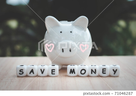 Dice the word "SAVE MONEY" and piggy bank money save coins.   Block of alphabet studded on wooden background. money investment concept. Savings. Copy space.. 71046287