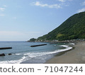 Mountains and coastline on a clear day .... with gentle waves 71047244