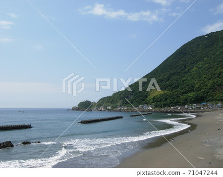 Mountains and coastline on a clear day .... with gentle waves 71047244